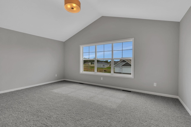 spare room with vaulted ceiling and carpet floors