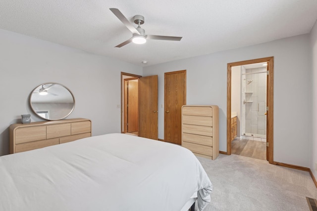 carpeted bedroom with ceiling fan, connected bathroom, and a textured ceiling