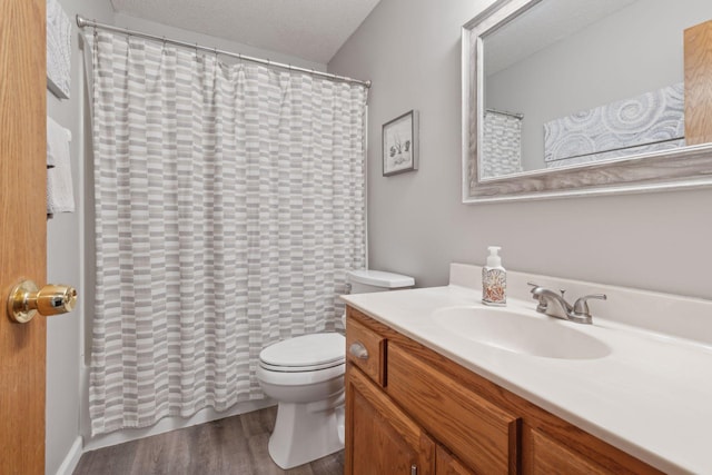 bathroom featuring hardwood / wood-style floors, a textured ceiling, toilet, and vanity