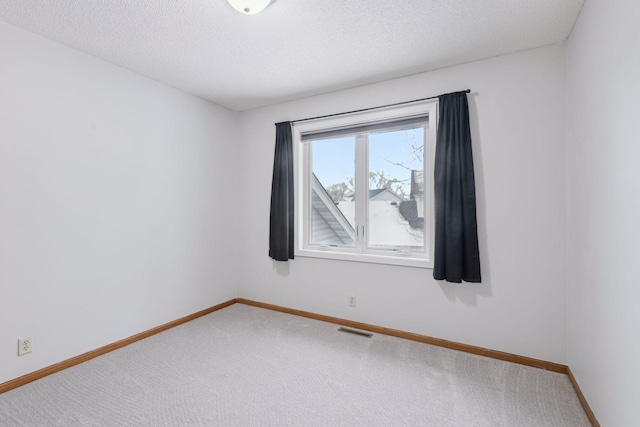 empty room featuring a textured ceiling and carpet floors