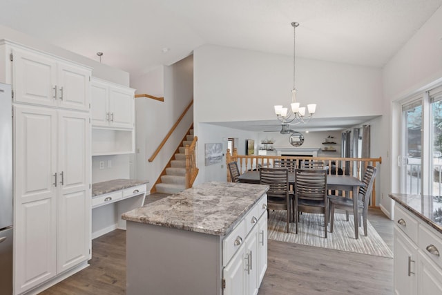 kitchen with white cabinets, hardwood / wood-style flooring, a center island, and pendant lighting