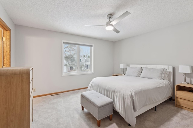 carpeted bedroom with ceiling fan and a textured ceiling