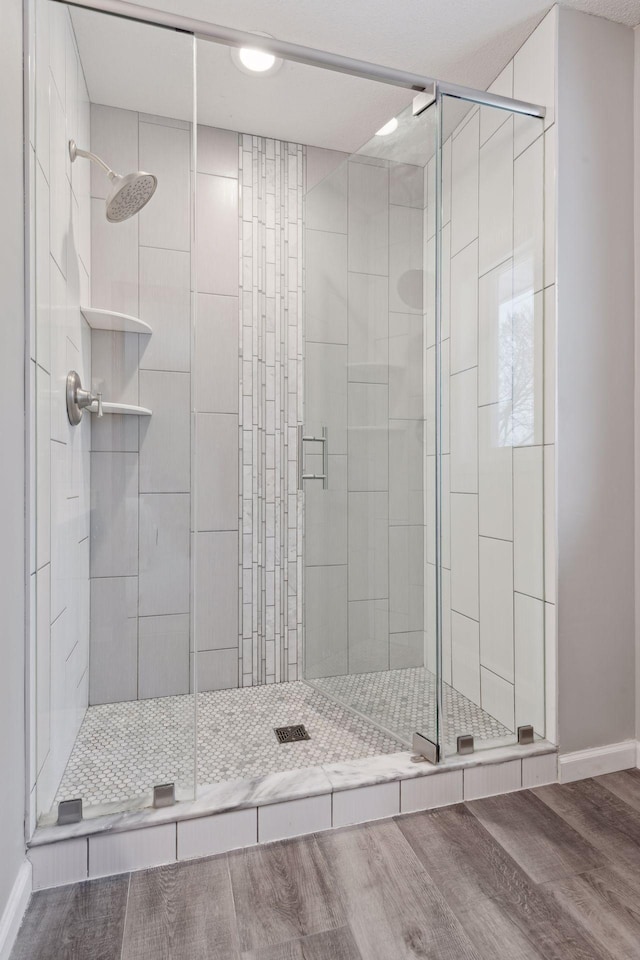 bathroom featuring wood-type flooring and an enclosed shower