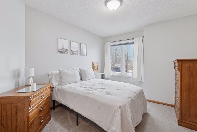 bedroom featuring light carpet and a textured ceiling