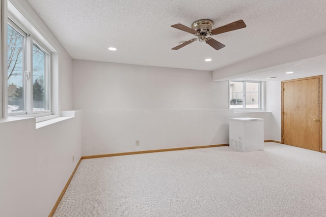 empty room with a textured ceiling, carpet floors, and ceiling fan