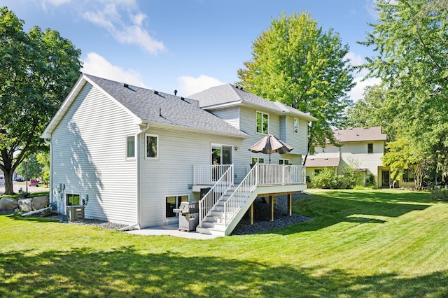 rear view of house featuring a lawn and a wooden deck