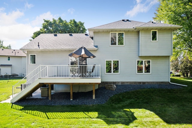 rear view of house with a deck and a lawn