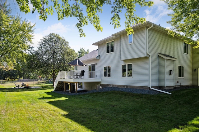 rear view of property with a lawn and a wooden deck