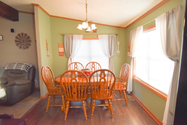 dining room featuring a healthy amount of sunlight, a textured ceiling, a chandelier, and hardwood / wood-style flooring