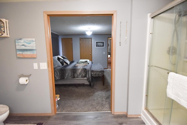 bathroom featuring toilet, hardwood / wood-style flooring, and walk in shower