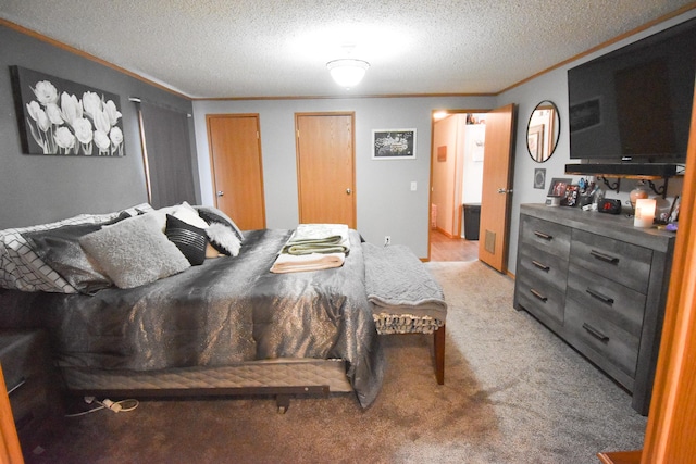 carpeted bedroom with a textured ceiling, ornamental molding, and multiple closets