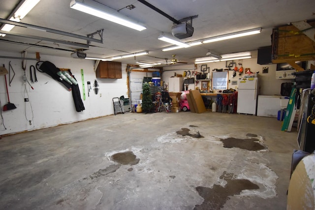 garage featuring white refrigerator, a workshop area, and a garage door opener