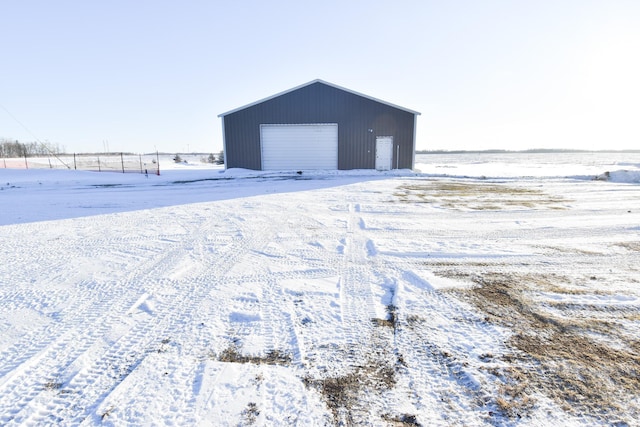 snow covered structure with a garage