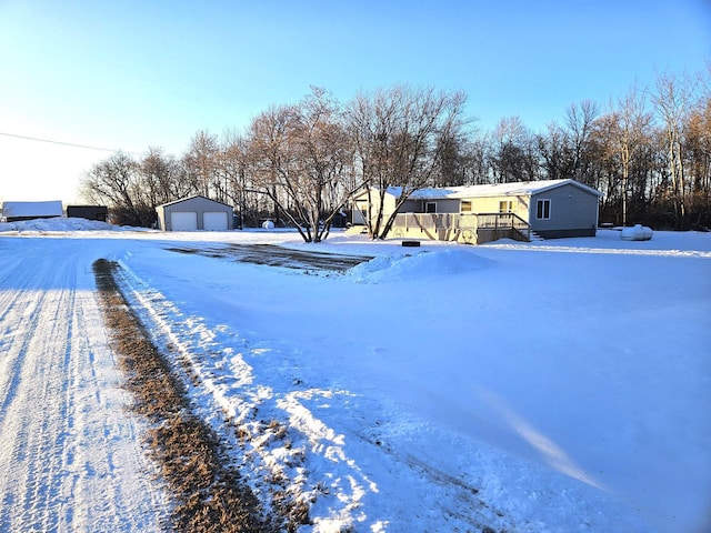 yard layered in snow with a garage and an outbuilding