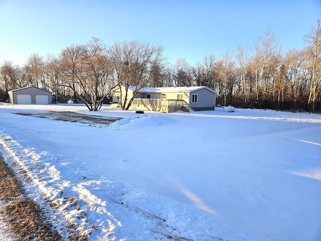 yard covered in snow with an outbuilding and a garage