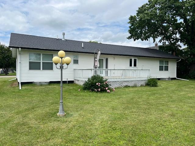 back of property featuring a yard and a wooden deck