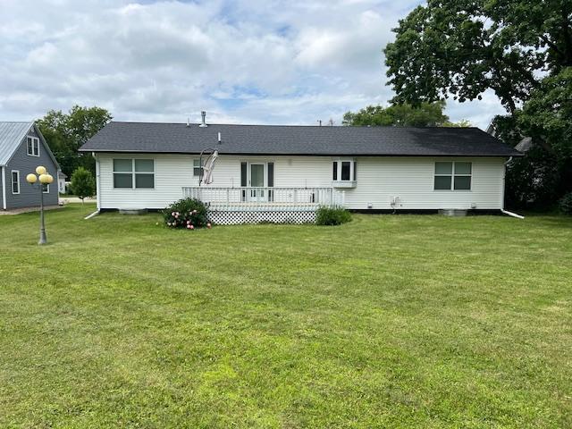 back of property featuring a lawn and a wooden deck