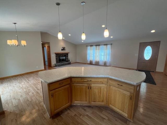 kitchen with hardwood / wood-style floors, a center island, a chandelier, and a fireplace