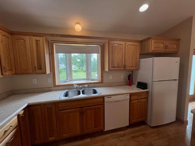 kitchen with white appliances, dark hardwood / wood-style flooring, and sink