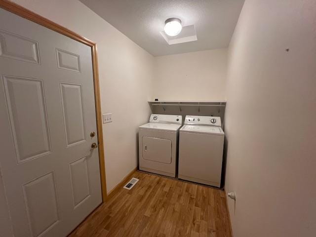 washroom featuring washer and dryer and light hardwood / wood-style floors