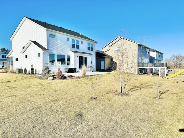 rear view of property featuring a yard, central AC unit, and a patio