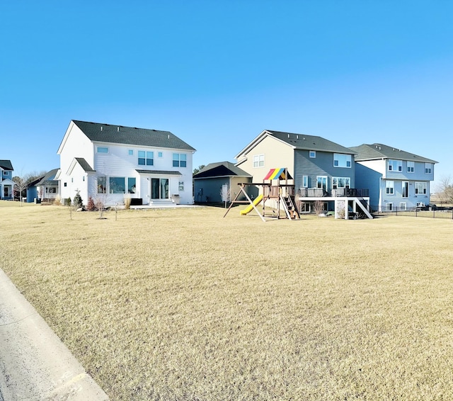 rear view of property featuring a yard and a playground