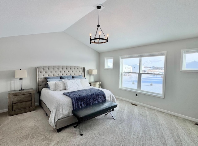 bedroom with light colored carpet, vaulted ceiling, and a chandelier