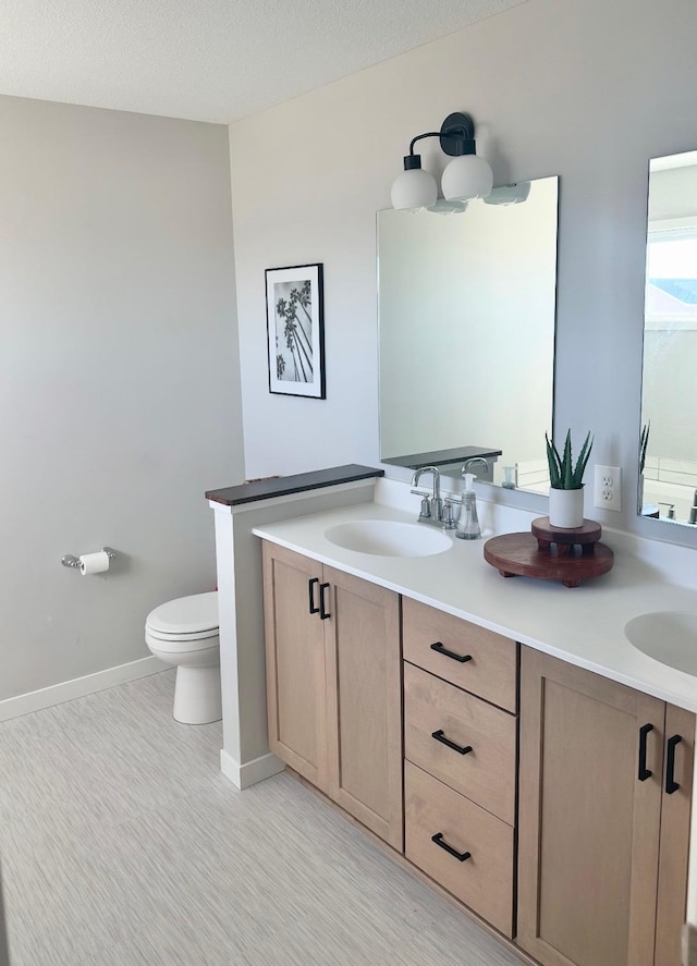 bathroom with toilet, vanity, a textured ceiling, and hardwood / wood-style floors