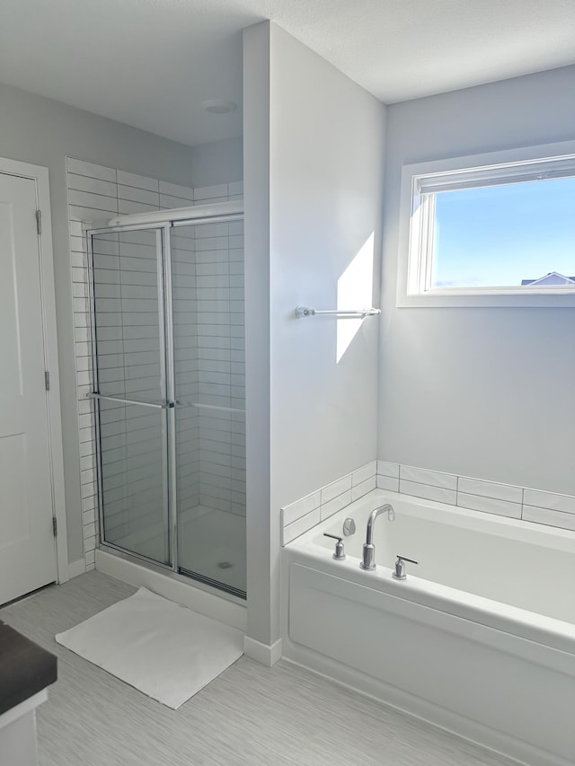 bathroom featuring shower with separate bathtub