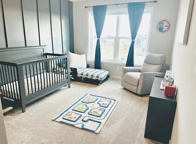 carpeted bedroom featuring a crib