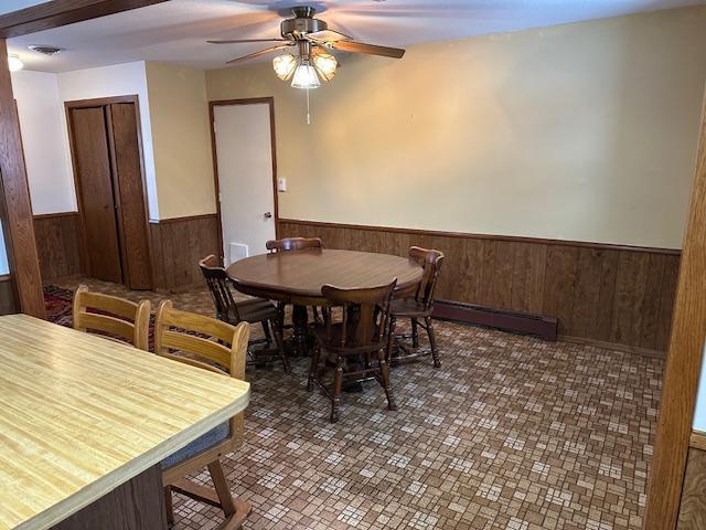 dining room featuring dark tile patterned floors, ceiling fan, and baseboard heating