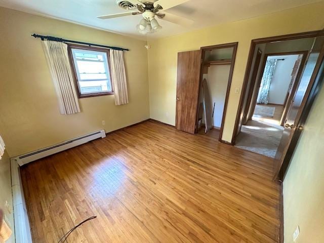 unfurnished bedroom featuring light hardwood / wood-style flooring, a baseboard radiator, and ceiling fan