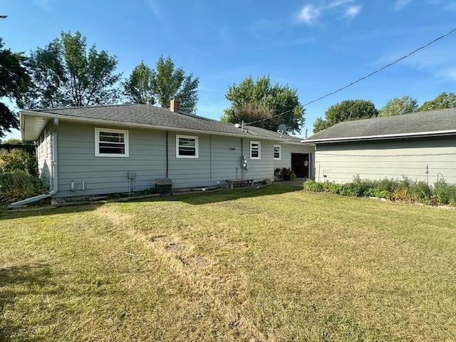 rear view of house featuring a yard