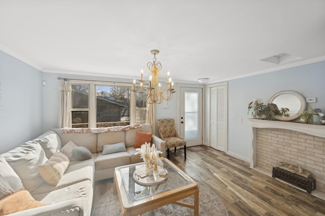 living room with hardwood / wood-style flooring, ornamental molding, and an inviting chandelier