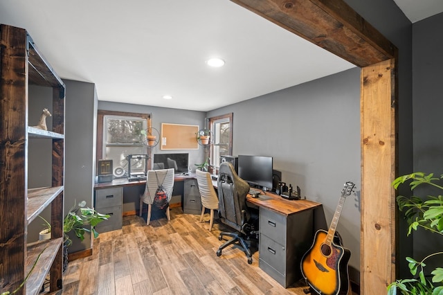 home office with a healthy amount of sunlight and light hardwood / wood-style flooring