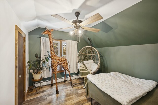 bedroom featuring ceiling fan, lofted ceiling, wood-type flooring, and a baseboard heating unit