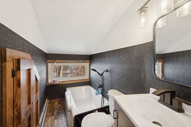 bathroom with vaulted ceiling, a washtub, a baseboard radiator, and toilet