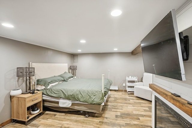 bedroom featuring a baseboard radiator and light hardwood / wood-style flooring