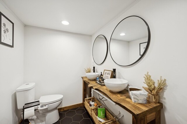 bathroom with ornamental molding, vanity, and toilet