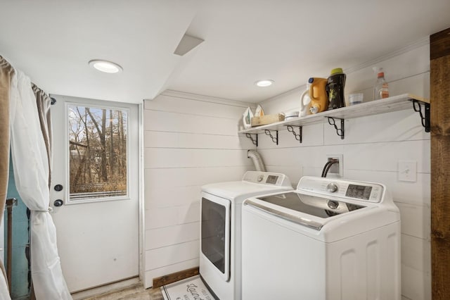 clothes washing area with light hardwood / wood-style flooring and washing machine and clothes dryer