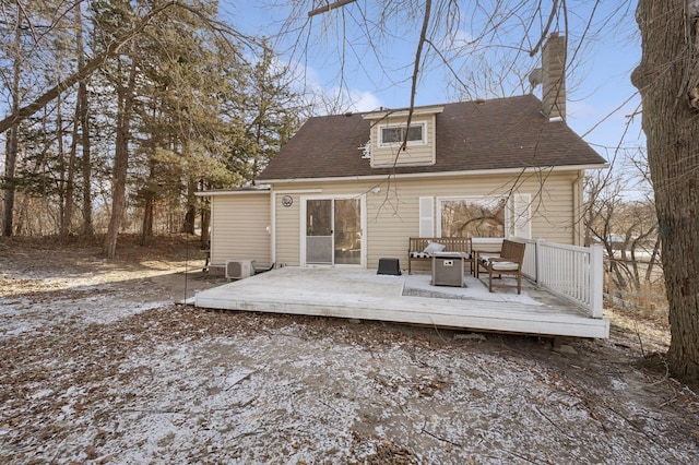 snow covered rear of property featuring a deck