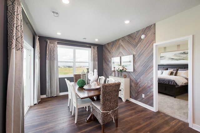 dining room featuring wood walls and dark hardwood / wood-style floors