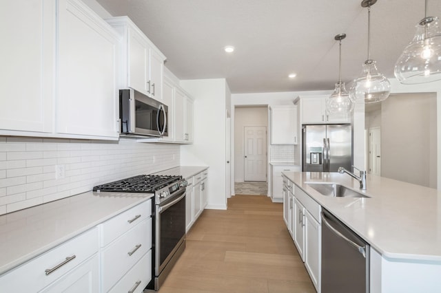 kitchen featuring white cabinets, pendant lighting, stainless steel appliances, and sink