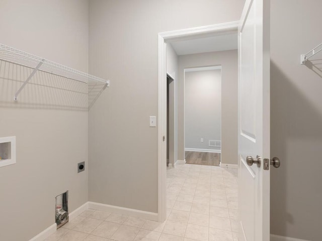 clothes washing area featuring hookup for a washing machine, light tile patterned floors, and electric dryer hookup