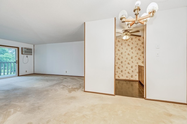 carpeted empty room featuring ceiling fan with notable chandelier and a wall mounted air conditioner