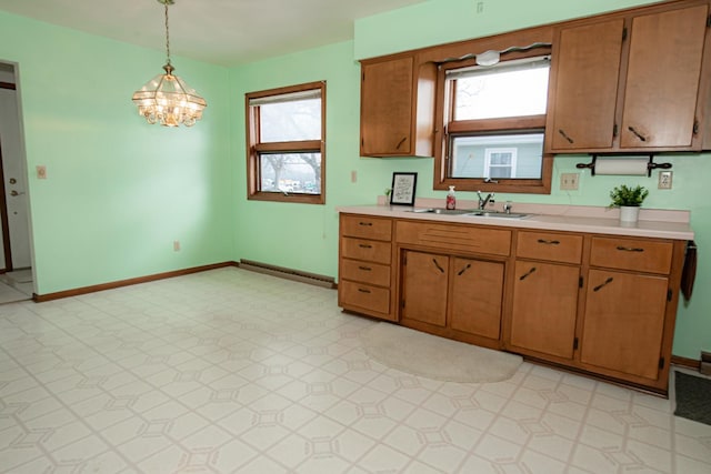 kitchen featuring sink, hanging light fixtures, a healthy amount of sunlight, and an inviting chandelier