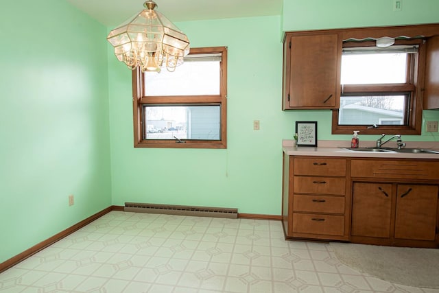 kitchen featuring sink, hanging light fixtures, an inviting chandelier, and a baseboard heating unit