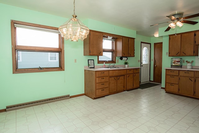 kitchen with ceiling fan with notable chandelier, sink, a baseboard radiator, and hanging light fixtures