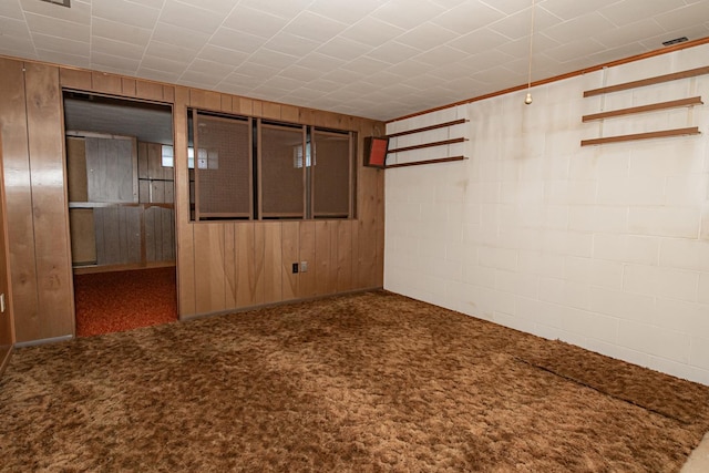 basement featuring wooden walls and carpet flooring