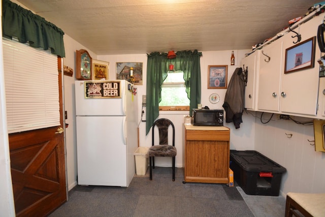 kitchen featuring white fridge and white cabinetry